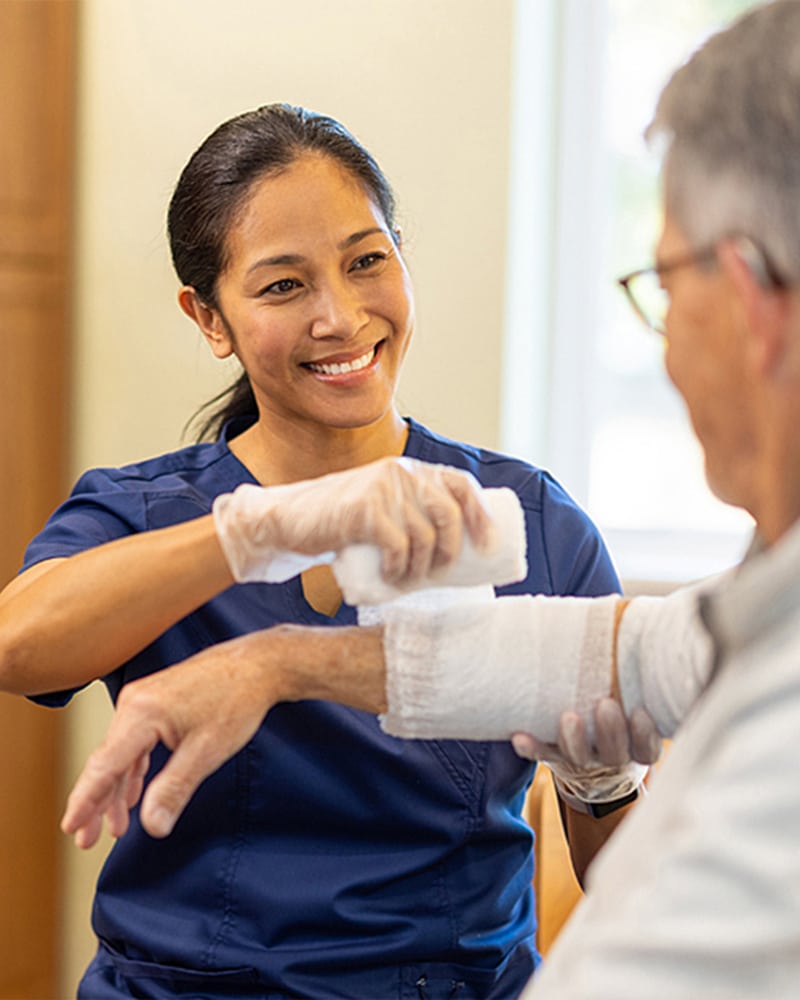 a nurse applies a bandage to a patient's arm